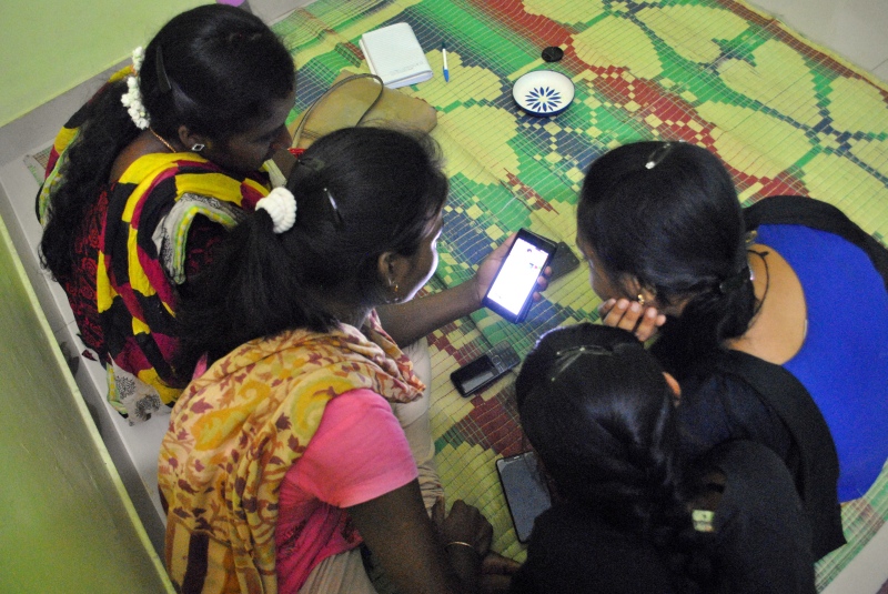 Migrant workers from Odisha and Jharkhand watch a YouTube video on how to make a cake in a pressure cooker. The girls want to throw one of their roommates a birthday party to rid her of homesickness. Photo credit: Rohini Mohan. Migrant workers from Odisha and Jharkhand watch a YouTube video on how to make a cake in a pressure cooker. The girls want to throw one of their roommates a birthday party to rid her of homesickness. Photo credit: Rohini Mohan.