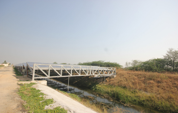 As the midday sun beats down relentlessly, solar panels fixed at an angle atop a 750 m long length of canal in Chandrasan village, Mehsana district, in India’s sunniest state of Gujarat, work quietly to produce power while saving evaporation of water that runs beneath. Image Credit: Mukta Patil As the midday sun beats down relentlessly, solar panels fixed at an angle atop a 750 m long length of canal in Chandrasan village, Mehsana district, in India’s sunniest state of Gujarat, work quietly to produce power while saving evaporation of water that runs beneath. Image Credit: Mukta Patil