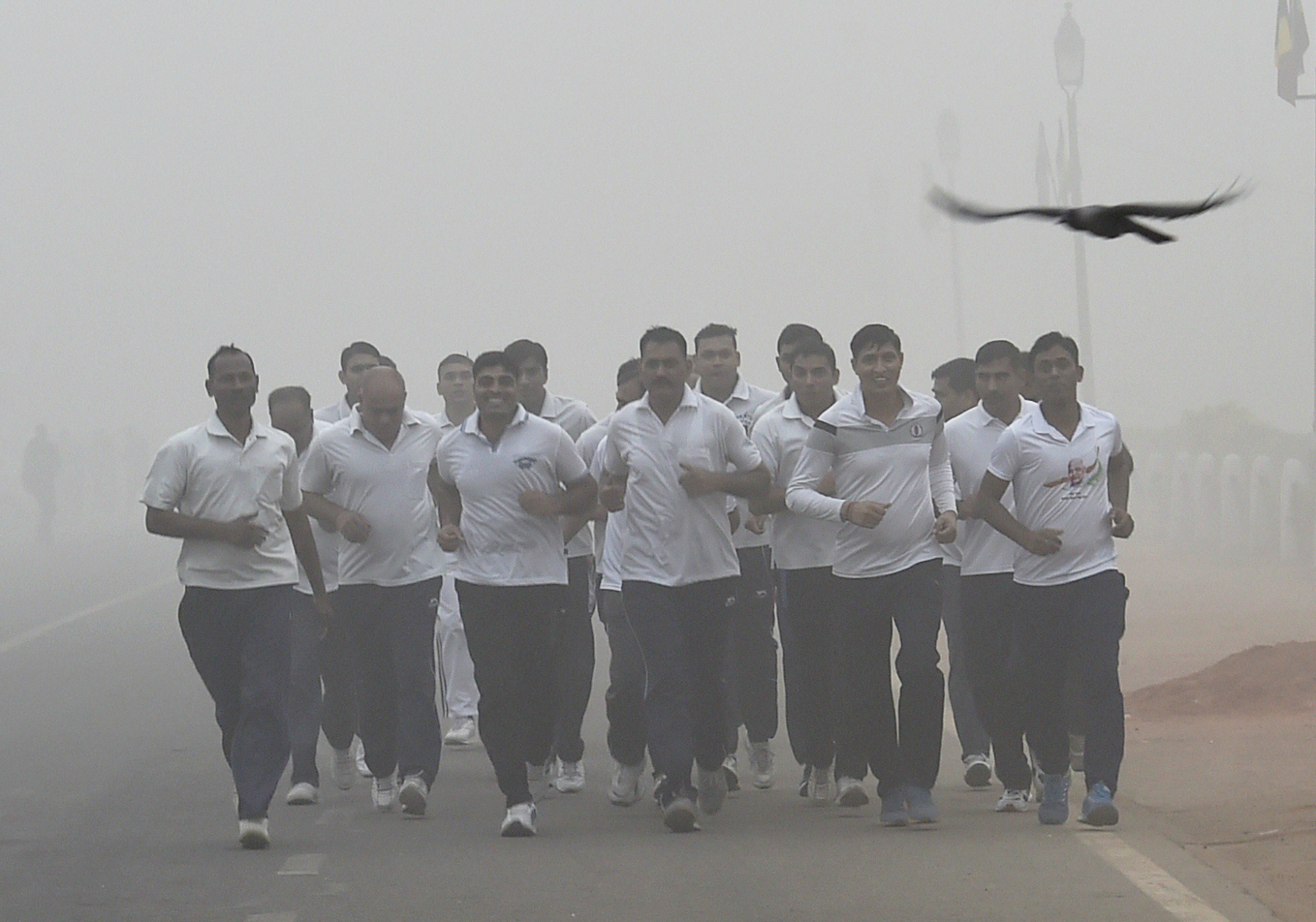 Security personnel jog through thick smog at Rajpath (PTI) Security personnel jog through thick smog at Rajpath (PTI)