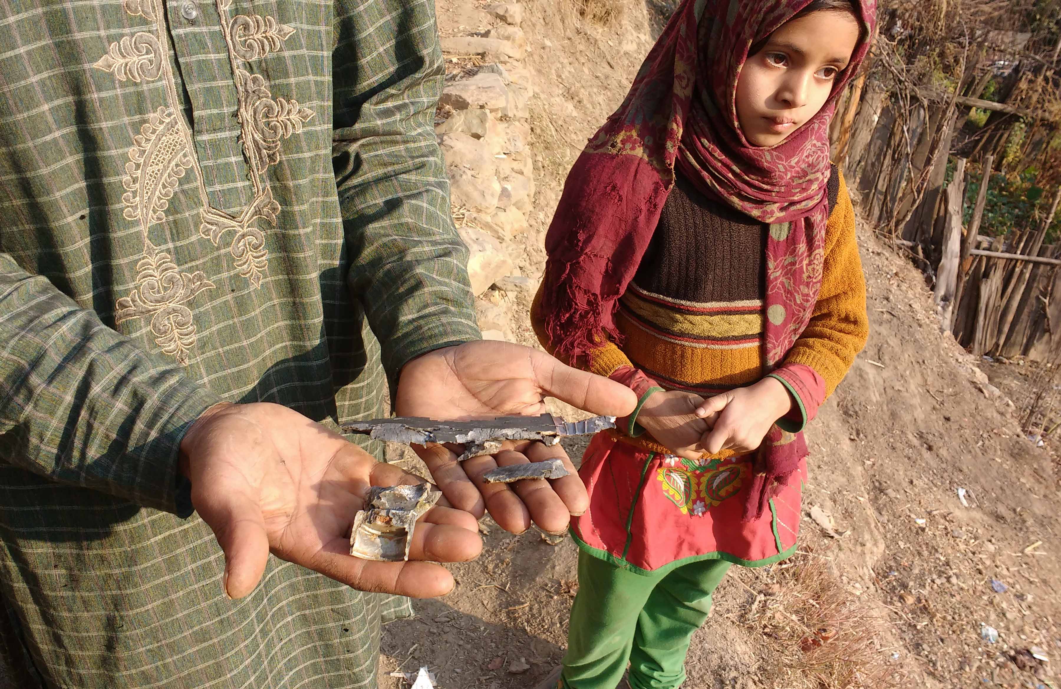Lal Hussain Lone holds shrapnel from shells that fell on his house in Mandiya village. Lal Hussain Lone holds shrapnel from shells that fell on his house in Mandiya village.