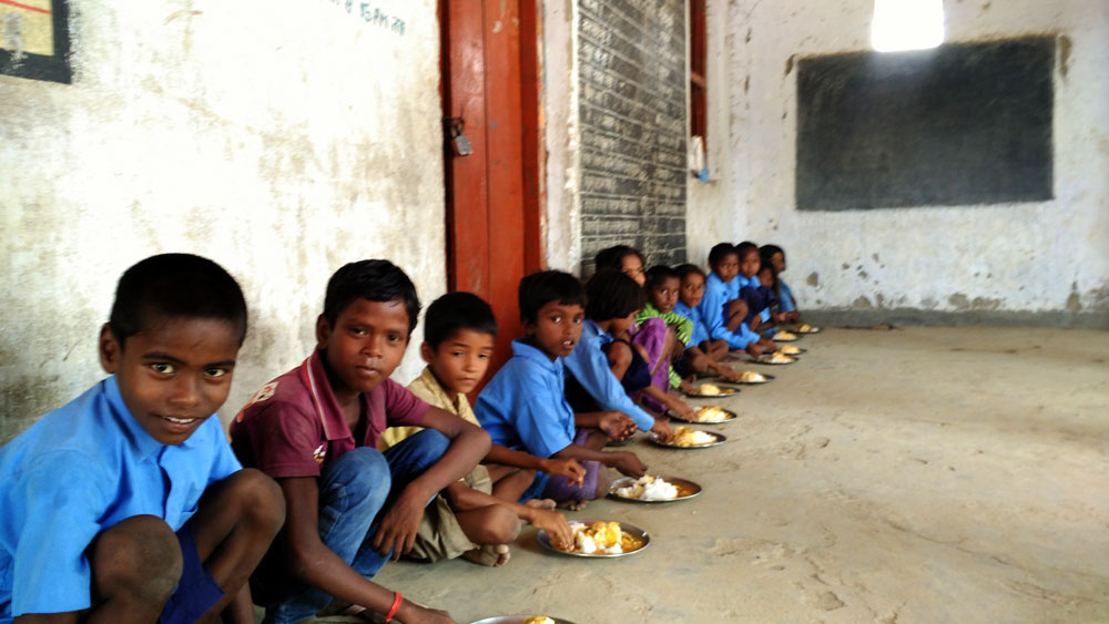 Children eating their mid-day meal at a school in Nauhar village in Banke Bazar, Gaya, in Bihar. Besides rations, the food security law provides for mid-day meals in schools. (Photo credit: Aashish Gupta). Children eating their mid-day meal at a school in Nauhar village in Banke Bazar, Gaya, in Bihar. Besides rations, the food security law provides for mid-day meals in schools. (Photo credit: Aashish Gupta).