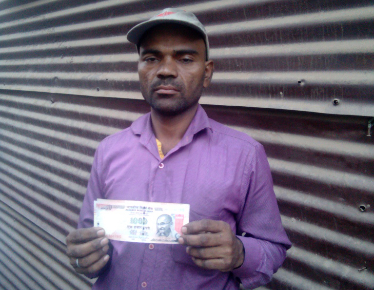 Loading-unloading worker Sanjay Kumar Yadav holds a Rs 1,000 note that he needs to get rid of. Loading-unloading worker Sanjay Kumar Yadav holds a Rs 1,000 note that he needs to get rid of.