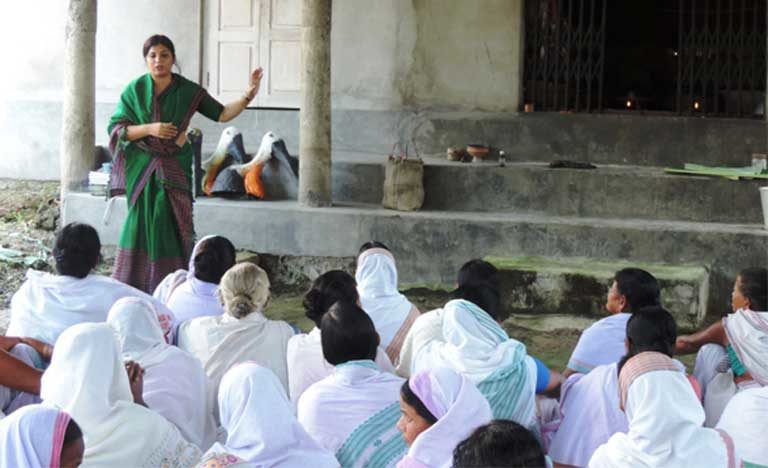 Purnima Barman speaks about Greater Adjutants to women at a village temple. The women have honored the bird that they now protect by adding it to sacred songs. Image Credit: Aaranyak Purnima Barman speaks about Greater Adjutants to women at a village temple. The women have honored the bird that they now protect by adding it to sacred songs. Image Credit: Aaranyak