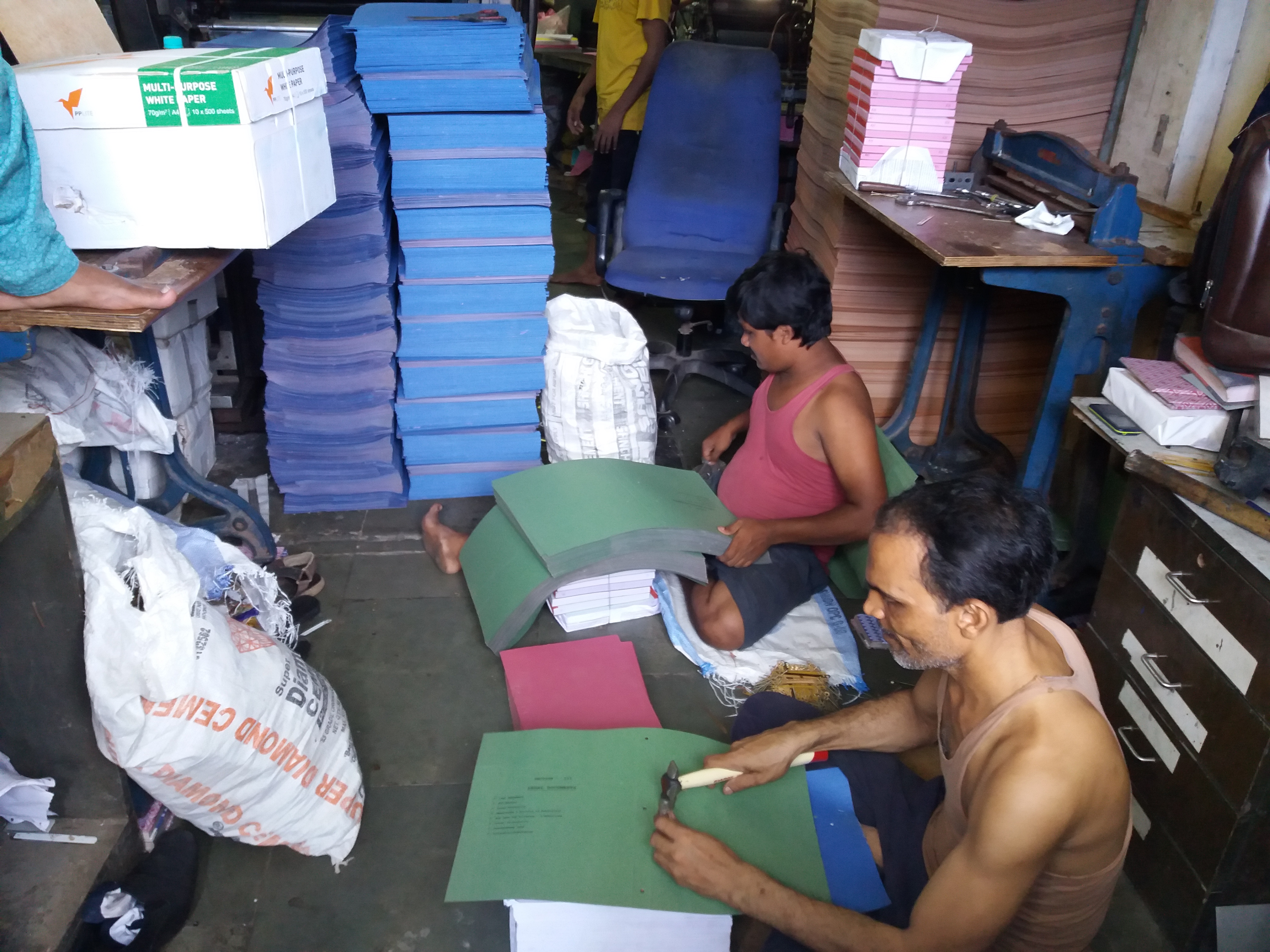 Workers at Deep Impac fasten metal clips to cardboard files. Photo credit: Aarefa Johari Workers at Deep Impac fasten metal clips to cardboard files. Photo credit: Aarefa Johari
