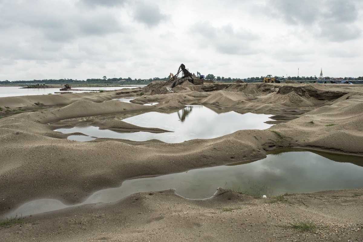 Piles of sand created by extraction along the Mekong River in Vientiane in May 2016. Grain by grain, truckload by truckload, Laos' section of the Mekong river is being dredged of sand to make cement – a commodity being devoured by a Chinese-led building boom in the Laos capital. (Photo credit: Lillian Suwanrumpha/AFP). Piles of sand created by extraction along the Mekong River in Vientiane in May 2016. Grain by grain, truckload by truckload, Laos' section of the Mekong river is being dredged of sand to make cement – a commodity being devoured by a Chinese-led building boom in the Laos capital. (Photo credit: Lillian Suwanrumpha/AFP).