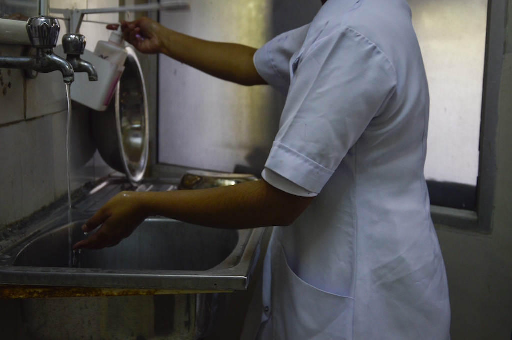 A nurse prepares and cleans her hands before a minor surgery. A nurse prepares and cleans her hands before a minor surgery.