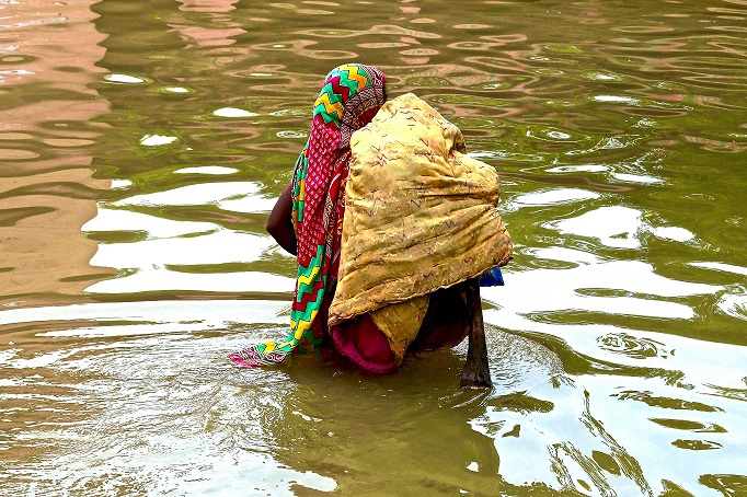 A woman makes her way through knee-deep flood waters. Credit: Eklavya Prasad A woman makes her way through knee-deep flood waters. Credit: Eklavya Prasad