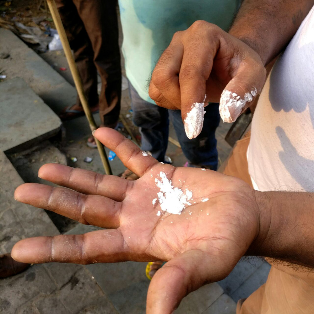 Johnny's fingers are covered in blemishes as he shows the arrowroot powder used as a glue substitute. Photo: Rhema Mukti Baxter Johnny's fingers are covered in blemishes as he shows the arrowroot powder used as a glue substitute. Photo: Rhema Mukti Baxter