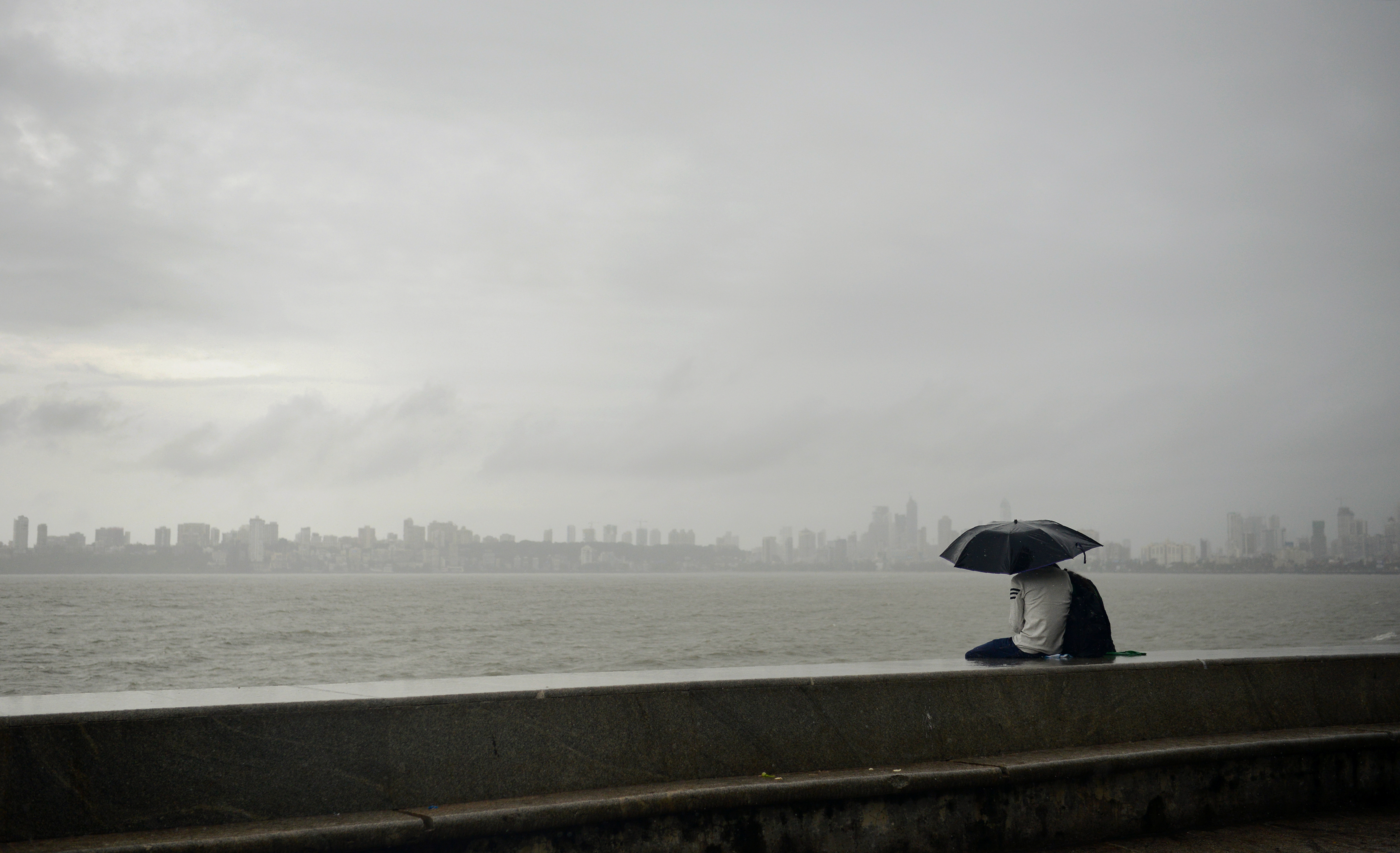 A couple watches the Mumbai skyline at Marine Drive. (Credit: Punit Paranjpe/AFP) A couple watches the Mumbai skyline at Marine Drive. (Credit: Punit Paranjpe/AFP)