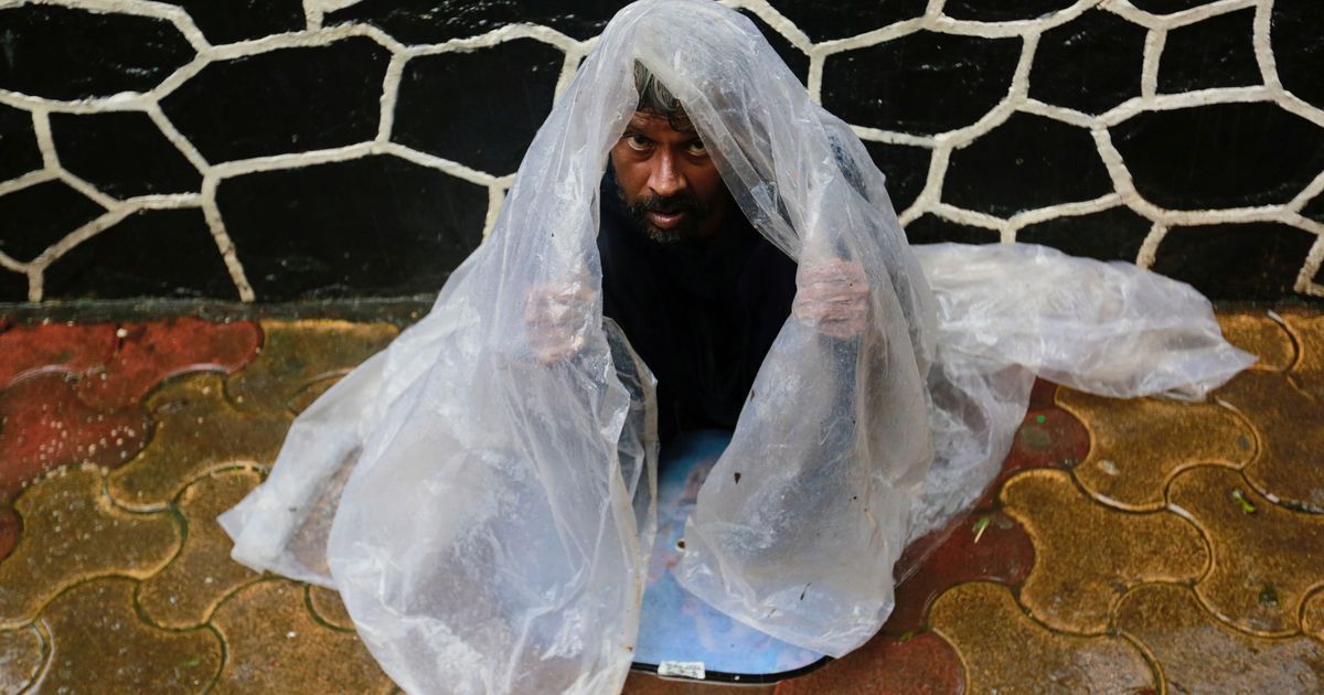A homeless man takes shelter under a plastic sheet as it pours in Mumbai. (Credit: Danish Siddiqui/Reuters) A homeless man takes shelter under a plastic sheet as it pours in Mumbai. (Credit: Danish Siddiqui/Reuters)