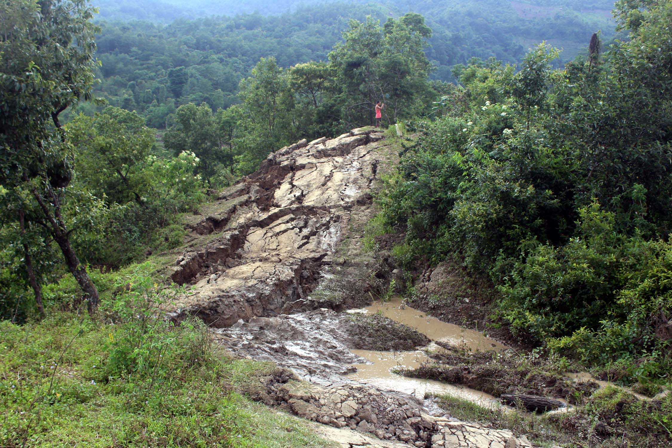 The road has been swept away towards the river.