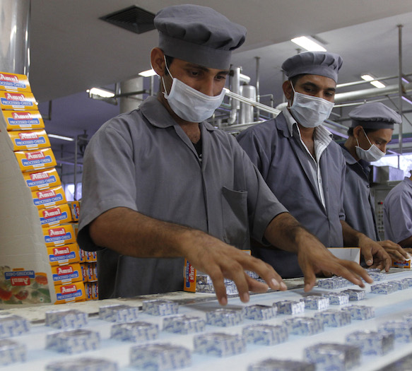 Workers pack processed cheese cubes at an Amul satellite dairy in Khatraj village. Photo credit: Reuters Workers pack processed cheese cubes at an Amul satellite dairy in Khatraj village. Photo credit: Reuters