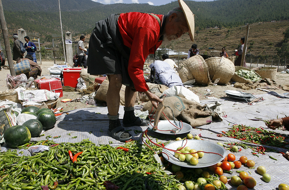 A man sells vegetables at a market in Punakha. Credits: Desmond Boylan/Reuters A man sells vegetables at a market in Punakha. Credits: Desmond Boylan/Reuters