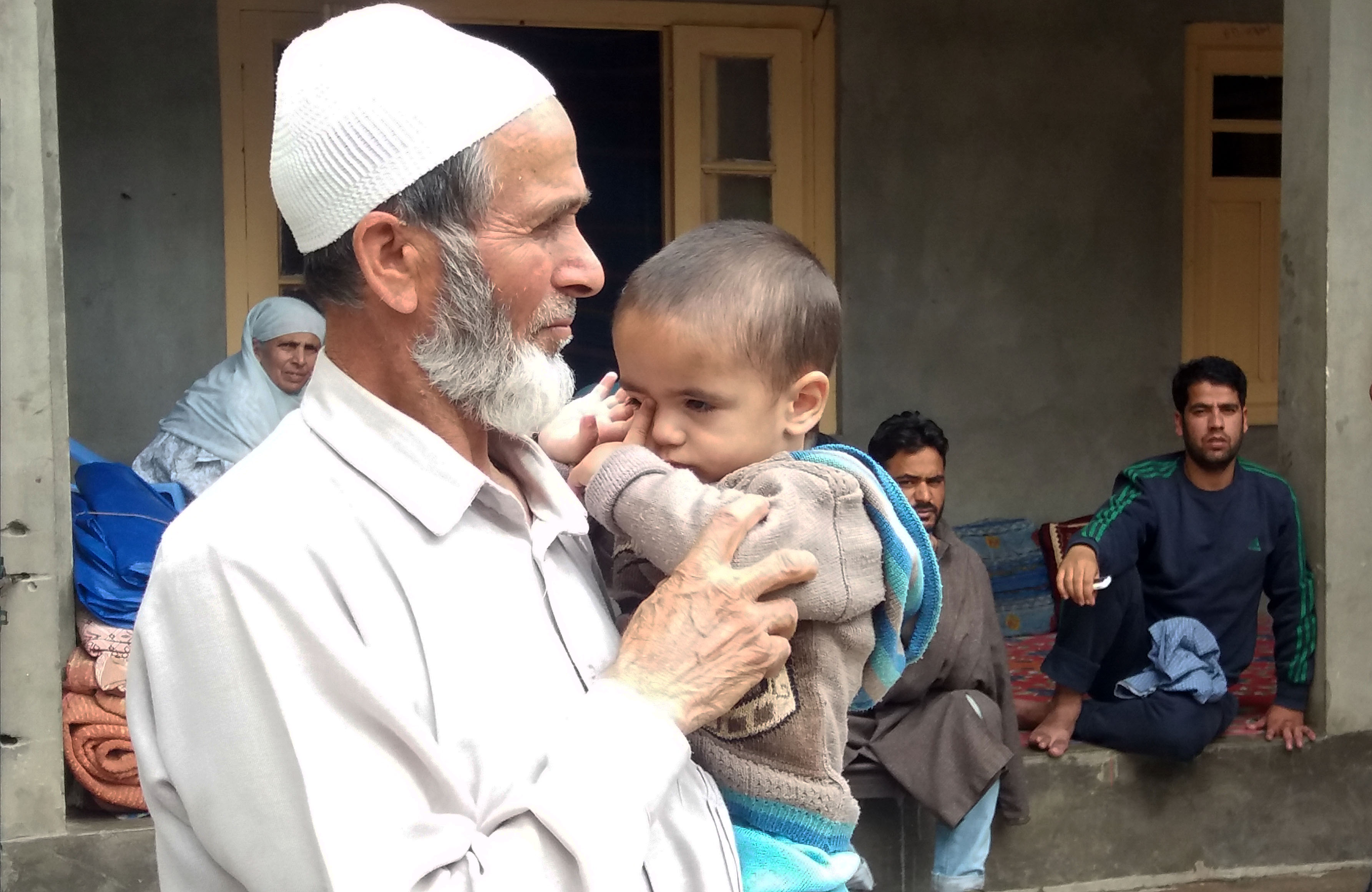 Wali Mohammad Mangoo, holds his deceased son’s 15-month-old child. (Photo credit: Ipsita Chakravarty). Wali Mohammad Mangoo, holds his deceased son’s 15-month-old child. (Photo credit: Ipsita Chakravarty).
