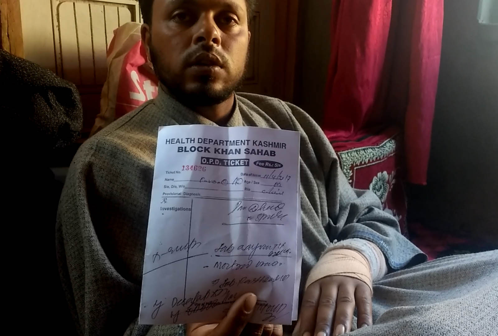 Farooq Dar displays his medical report. Credit: Rayan Naqash